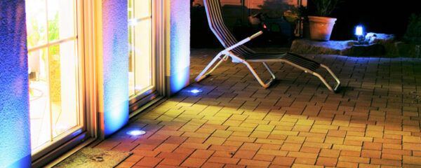 terrasse illuminée de nuit par des spots LED extérieurs diffusant une lumière légèrement bleutée