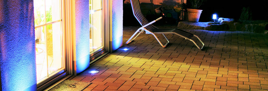 terrasse illuminée de nuit par des spots LED extérieurs diffusant une lumière légèrement bleutée